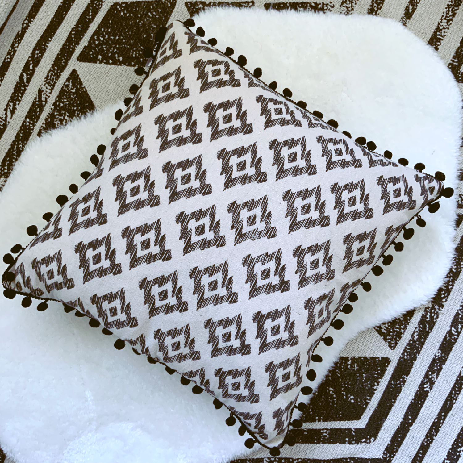 This Mia Aztec Cushion is perfect for updating any bedroom. Crafted from cream cotton, it features a black pom pom edging and a stylish Aztec print for a contemporary look. Soft and comfortable, with a polyester filling and measuring 45 x 45cm, this cushion is sure to bring a modern touch to your space and the perfect cushion for your bed or sofa. Available as a filled cushion. 